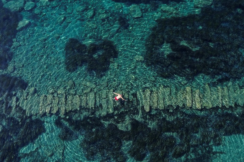 taman arkeologi bawah laut di pelabuhan kuno Amathus di Limassol, Siprus Orang-orang bersiap untuk mengunjungi taman arkeologi bawah laut di pelabuhan kuno Amathus di Limassol, Siprus, Sabtu (9/7/2022). (REUTERS/Yiannis Kourtoglou)