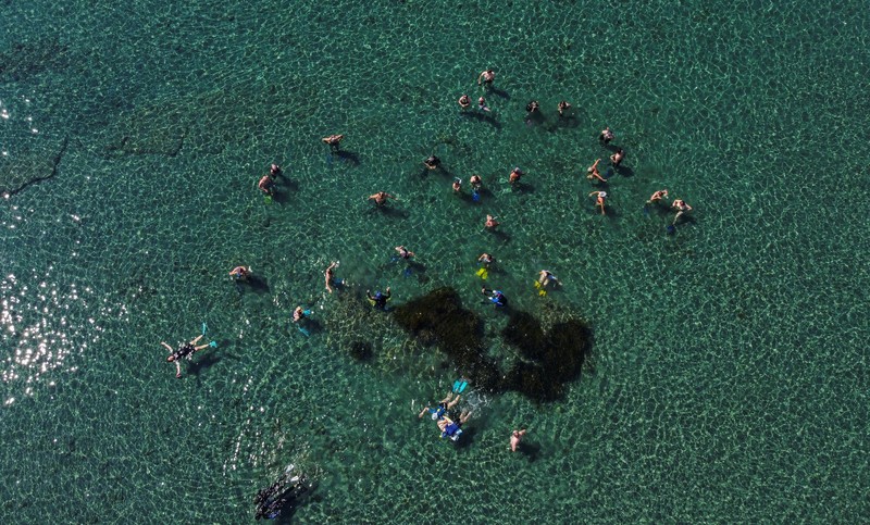 Orang-orang bersiap untuk mengunjungi taman arkeologi bawah laut di pelabuhan kuno Amathus di Limassol, Siprus, Sabtu (9/7/2022). (REUTERS/Yiannis Kourtoglou)