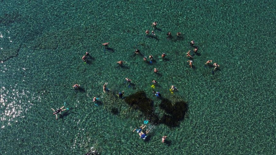 Orang-orang bersiap untuk mengunjungi taman arkeologi bawah laut di pelabuhan kuno Amathus di Limassol, Siprus, Sabtu (9/7/2022). (REUTERS/Yiannis Kourtoglou)