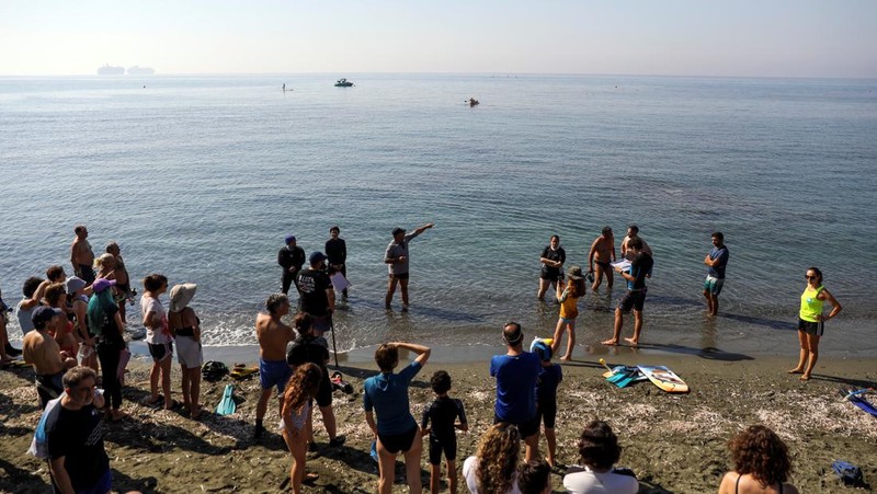 Orang-orang bersiap untuk mengunjungi taman arkeologi bawah laut di pelabuhan kuno Amathus di Limassol, Siprus, Sabtu (9/7/2022). (REUTERS/Yiannis Kourtoglou)