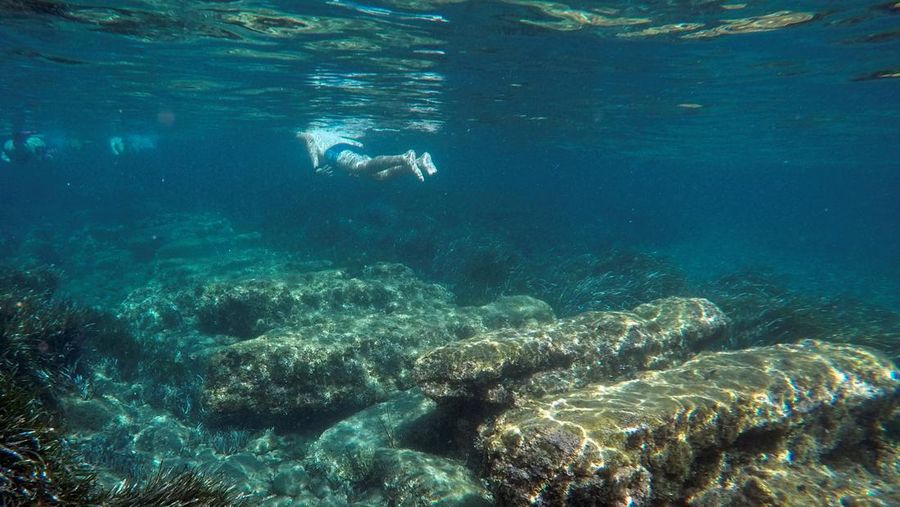 Orang-orang bersiap untuk mengunjungi taman arkeologi bawah laut di pelabuhan kuno Amathus di Limassol, Siprus, Sabtu (9/7/2022). (REUTERS/Yiannis Kourtoglou)