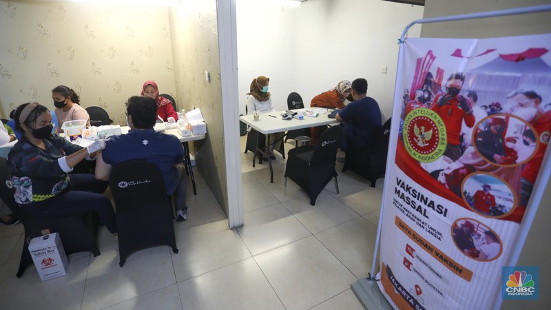 Tenaga kesehatan menyuntikan vaksin COVID-19 kepeda warga saat pelaksanaan vaksinasi massal di Kota Kasablanka, Jakarta, Senin (18/7/2022). Pemprov DKI Jakarta memberlakukan syarat vaksinasi booster untuk masyarakat yang beraktivitas di fasilitas umum seperti sektor perkantoran, mal hingga tempat pariwisata di Jakarta. (CNBC Indonesia/Andrean Kristianto)