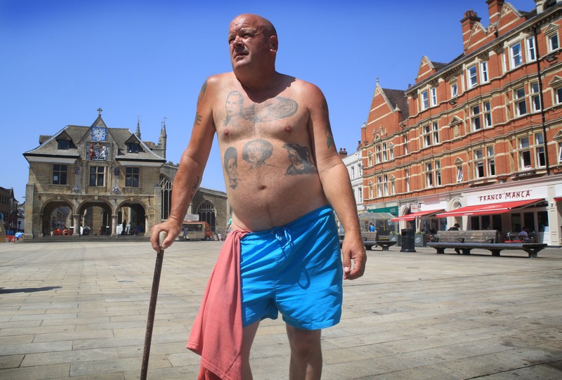 Badger, seorang pensiunan roofer berjemur di bawah sinar matahari yang brutal di Cathedral Square pada 18 Juli 2022 di Peterborough, Inggris. (Getty Images/Martin Pope)