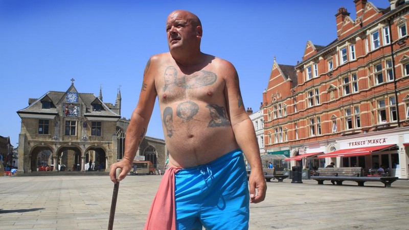 Badger, seorang pensiunan roofer berjemur di bawah sinar matahari yang brutal di Cathedral Square pada 18 Juli 2022 di Peterborough, Inggris. (Getty Images/Martin Pope)