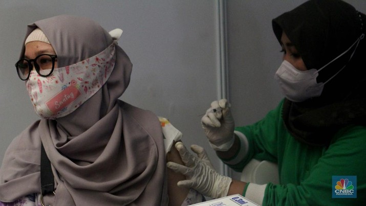 Pengunjung mall mengantri untuk melakukan vaksinasi dosis ketiga covid-19 di mall Bale Kota Tangerang, Banten, Selasa 19/07. Pemerintah resmi memberlakukan wajib vaksin booster atau dosis ketiga untuk masuk mal atau area publik lainnya. (CNBC Indonesia/Muhammad Sabki)