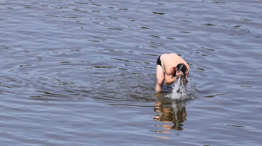Seorang pria menyegarkan diri di sungai Rhine setelah berjemur di tepi sungai selama gelombang panas pada 18 Juli 2022 di Cologne, Jerman. (Getty Images/Andreas Rentz)