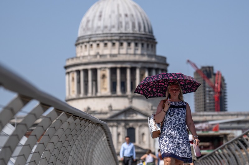 Badger, seorang pensiunan roofer berjemur di bawah sinar matahari yang brutal di Cathedral Square pada 18 Juli 2022 di Peterborough, Inggris. (Getty Images/Martin Pope)