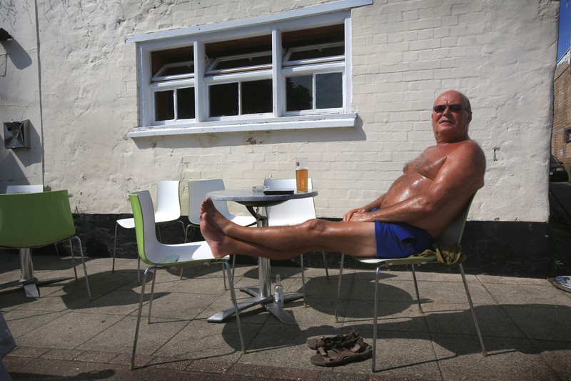Badger, seorang pensiunan roofer berjemur di bawah sinar matahari yang brutal di Cathedral Square pada 18 Juli 2022 di Peterborough, Inggris. (Getty Images/Martin Pope)