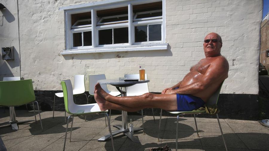 Badger, seorang pensiunan roofer berjemur di bawah sinar matahari yang brutal di Cathedral Square pada 18 Juli 2022 di Peterborough, Inggris. (Getty Images/Martin Pope)