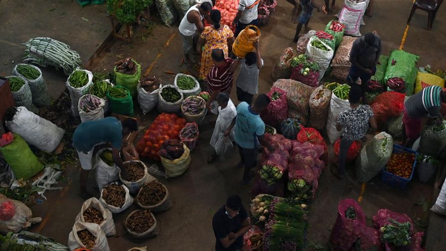 Orang-orang berbelanja di pasar grosir sayur dan buah di tengah krisis ekonomi yang sedang berlangsung di pinggiran Kolombo. (AFP via Getty Images/ARUN SANKAR)