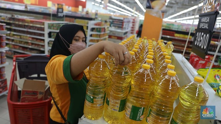 Petugas menata minyak goreng kemasan di Supermarket Jakarta, Kamis 21/7. Harga minyak goreng kemasan terus mengalami penurunan di toko ritel. (CNBC Indonesia/Muhammad Sabki)