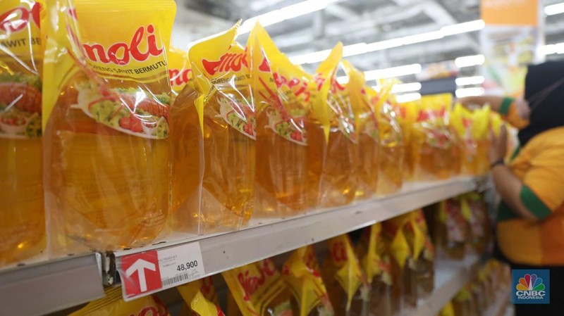 Petugas menata minyak goreng kemasan di Supermarket Jakarta, Kamis 21/7. Harga minyak goreng kemasan terus mengalami penurunan di toko ritel. (CNBC Indonesia/Muhammad Sabki)