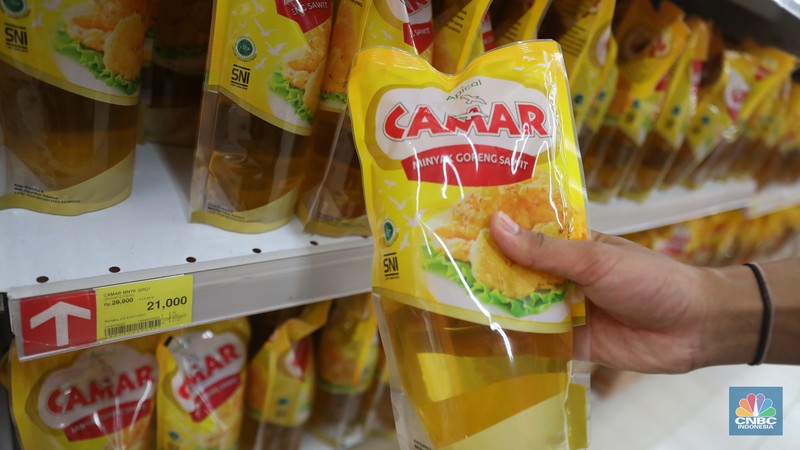 Petugas menata minyak goreng kemasan di Supermarket Jakarta, Kamis 21/7. Harga minyak goreng kemasan terus mengalami penurunan di toko ritel. (CNBC Indonesia/Muhammad Sabki)