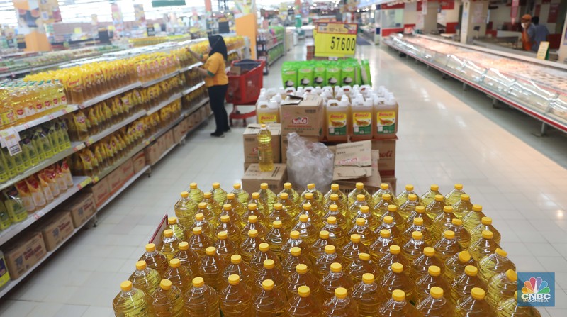 Petugas menata minyak goreng kemasan di Supermarket Jakarta, Kamis 21/7. Harga minyak goreng kemasan terus mengalami penurunan di toko ritel. (CNBC Indonesia/Muhammad Sabki)