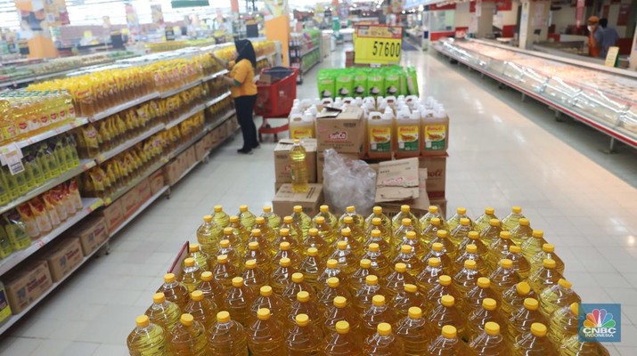 Petugas menata minyak goreng kemasan di Supermarket Jakarta, Kamis 21/7. Harga minyak goreng kemasan terus mengalami penurunan di toko ritel. (CNBC Indonesia/Muhammad Sabki)
