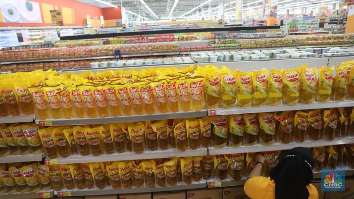 Petugas menata minyak goreng kemasan di Supermarket Jakarta, Kamis 21/7. Harga minyak goreng kemasan terus mengalami penurunan di toko ritel. (CNBC Indonesia/Muhammad Sabki)