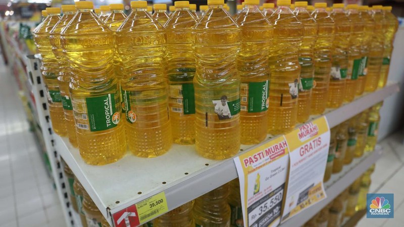 Petugas menata minyak goreng kemasan di Supermarket Jakarta, Kamis 21/7. Harga minyak goreng kemasan terus mengalami penurunan di toko ritel. (CNBC Indonesia/Muhammad Sabki)