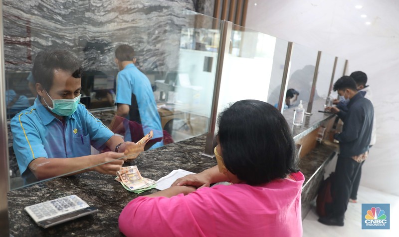 Petugas menghitung uang di tempat penukaran uang Luxury Valuta Perkasa, Blok M, Jakarta, Kamis, 21/7. Rupiah tertekan pada perdagangan Kamis (21/7/2022) (CNBC Indonesia/Muhammad Sabki)