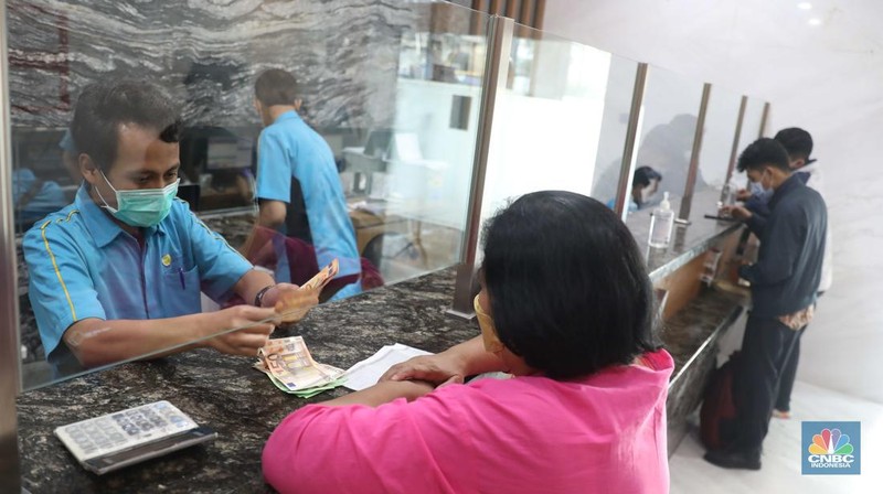 Petugas menghitung uang di tempat penukaran uang Luxury Valuta Perkasa, Blok M, Jakarta, Kamis, 21/7. Rupiah tertekan pada perdagangan Kamis (21/7/2022) (CNBC Indonesia/Muhammad Sabki)