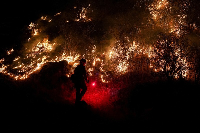 10 Tanker aircraft flies over the Oak Fire as it burns near Darrah in Mariposa County, California, U.S. July 23, 2022.  REUTERS/David Swanson