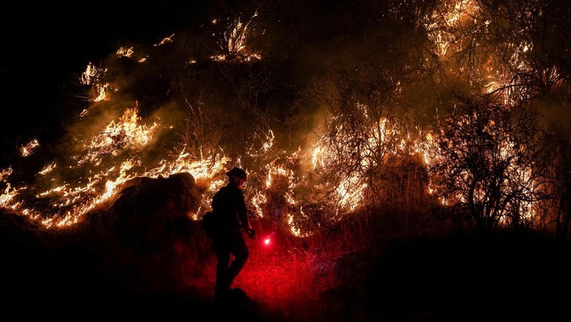 10 Tanker aircraft flies over the Oak Fire as it burns near Darrah in Mariposa County, California, U.S. July 23, 2022.  REUTERS/David Swanson