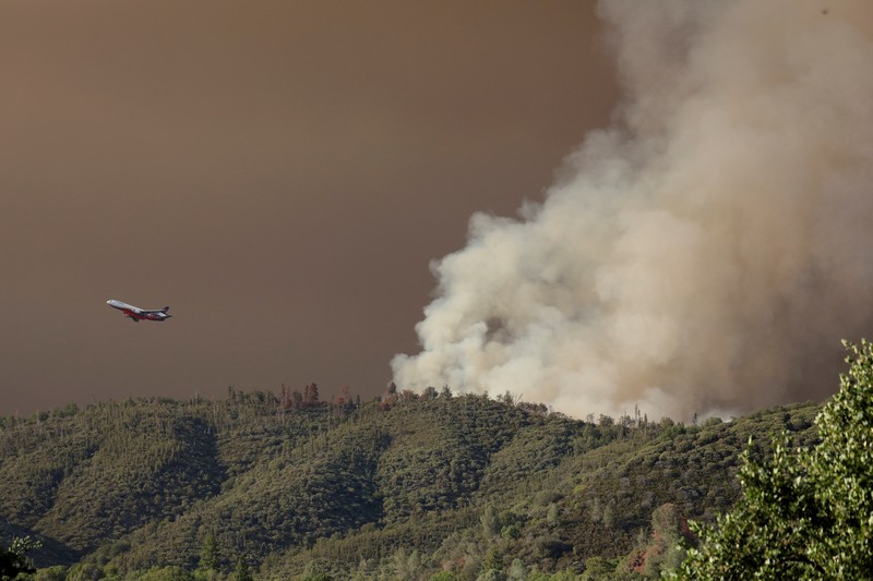 CALIFORNIA-WILDFIRES/ 10 Tanker aircraft flies over the Oak Fire as it burns near Darrah in Mariposa County, California, U.S. July 23, 2022. REUTERS/David Swanson
