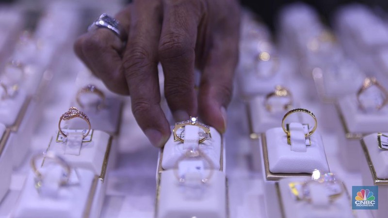 Pemilik toko perhiasan menata perhiasan emas di Kawasan Cikini Gold Center, Jakarta, Senin, (25/7/2022). (CNBC Indonesia/Muhammad Sabki)