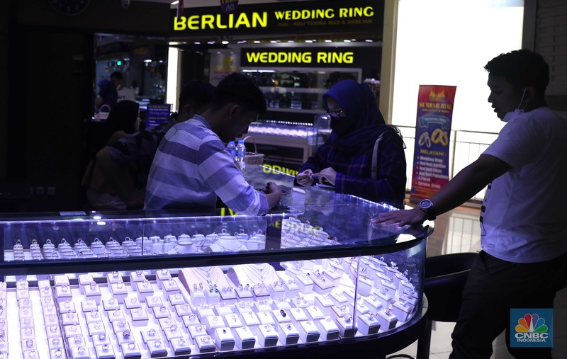 Pemilik toko perhiasan menata perhiasan emas di Kawasan Cikini Gold Center, Jakarta, Senin, (25/7/2022). (CNBC Indonesia/Muhammad Sabki)