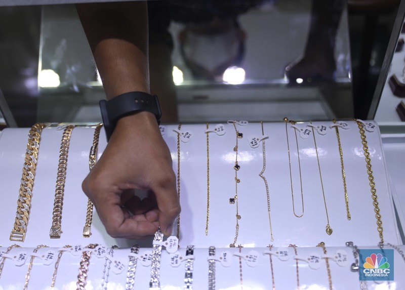 Pemilik toko perhiasan menata perhiasan emas di Kawasan Cikini Gold Center, Jakarta, Senin, (25/7/2022). (CNBC Indonesia/Muhammad Sabki)