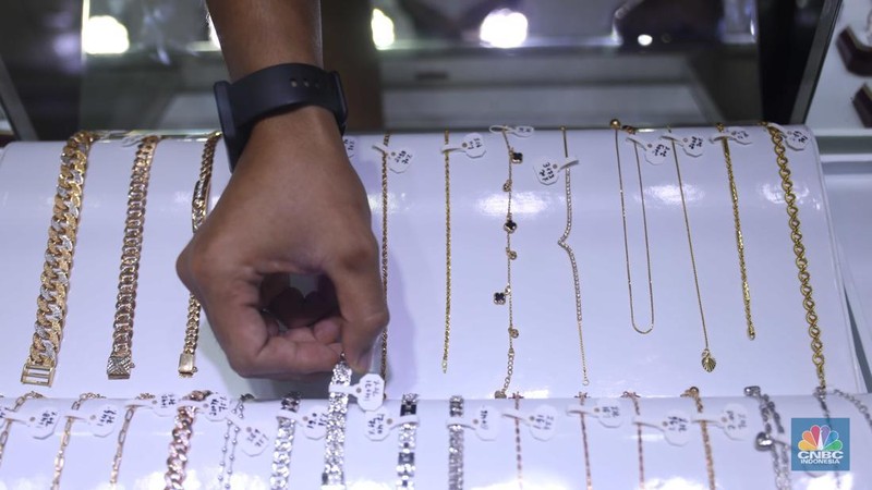 Pemilik toko perhiasan menata perhiasan emas di Kawasan Cikini Gold Center, Jakarta, Senin, (25/7/2022). (CNBC Indonesia/Muhammad Sabki)