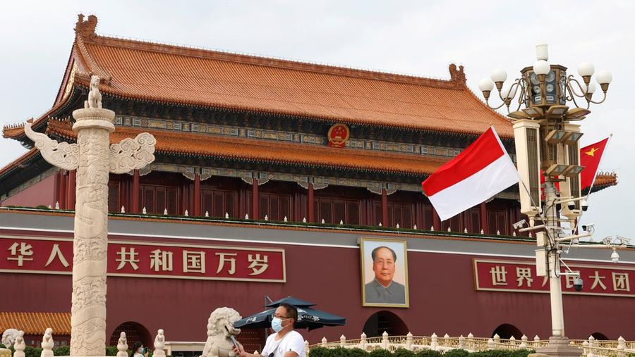 Seorang pria bersepeda melewati bendera Indonesia dan China di depan Gerbang Tiananmen, saat Presiden Indonesia Joko Widodo mengunjungi Beijing, China 25 Juli 2022. (REUTERS/CARLOS GARCIA RAWLINS)