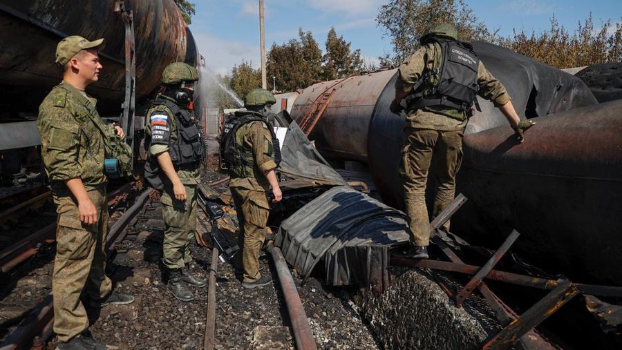 Penyelidik militer Rusia bekerja di lokasi kebakaran di depot minyak di distrik Budyonnovsky di Donetsk, Ukraina, 26 Juli 2022. (REUTERS/STRINGER)