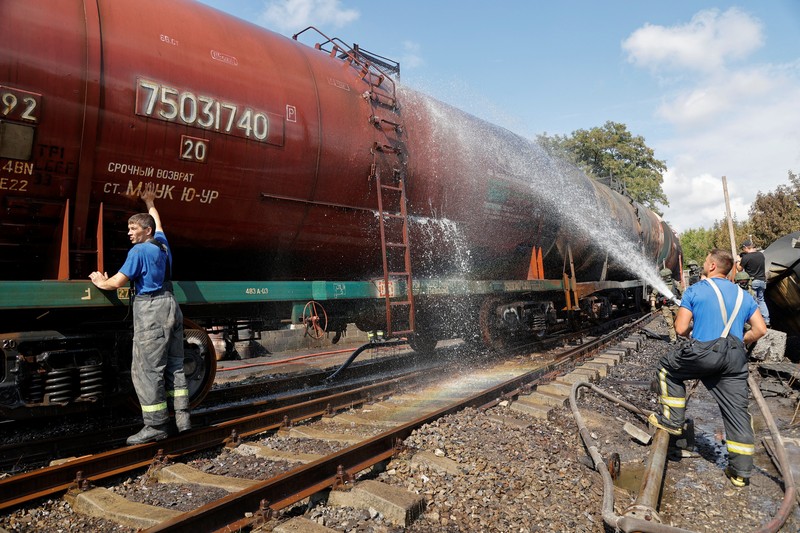 Penyelidik militer Rusia bekerja di lokasi kebakaran di depot minyak di distrik Budyonnovsky di Donetsk, Ukraina, 26 Juli 2022. (REUTERS/STRINGER)