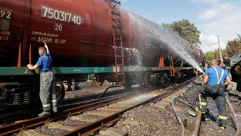 Penyelidik militer Rusia bekerja di lokasi kebakaran di depot minyak di distrik Budyonnovsky di Donetsk, Ukraina, 26 Juli 2022. (REUTERS/STRINGER)