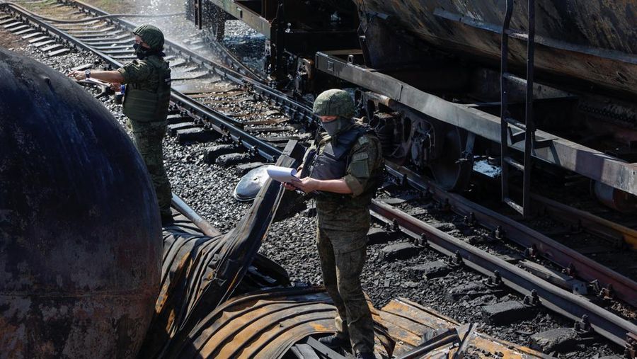 Penyelidik militer Rusia bekerja di lokasi kebakaran di depot minyak di distrik Budyonnovsky di Donetsk, Ukraina, 26 Juli 2022. (REUTERS/STRINGER)