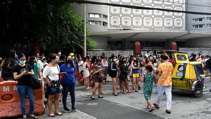 Warga menyelamatkan diri ke luar gedung setelah gempa berkekuatan 7,1 SR, sekitar 300 kilometer jauhnya, terasa di Manila pada 27 Juli 2022. (AFP via Getty Images/JAM STA ROSA)