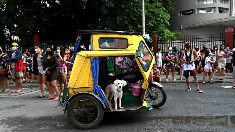 Warga menyelamatkan diri ke luar gedung setelah gempa berkekuatan 7,1 SR, sekitar 300 kilometer jauhnya, terasa di Manila pada 27 Juli 2022. (AFP via Getty Images/JAM STA ROSA)
