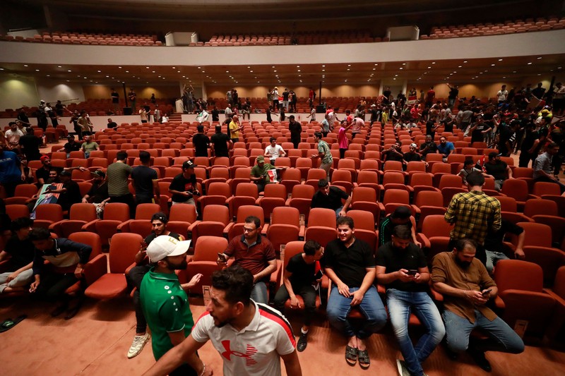 Pendukung ulama Irak Moqtada Sadr berkumpul di luar parlemen Irak di Zona Hijau keamanan tinggi ibukota Baghdad, saat mereka memprotes pencalonan blok saingan untuk perdana menteri, pada 27 Juli 2022. (AFP via Getty Images/AHMAD AL-RUBAYE)