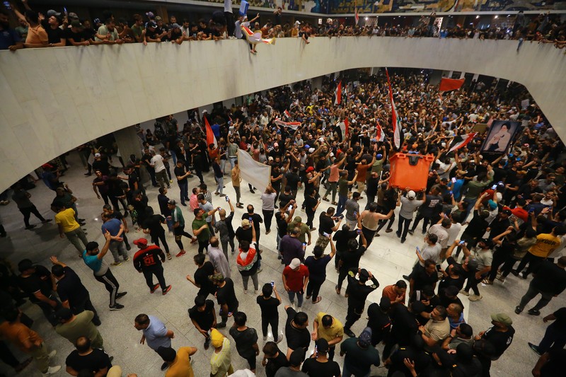 Pendukung ulama Irak Moqtada Sadr berkumpul di luar parlemen Irak di Zona Hijau keamanan tinggi ibukota Baghdad, saat mereka memprotes pencalonan blok saingan untuk perdana menteri, pada 27 Juli 2022. (AFP via Getty Images/AHMAD AL-RUBAYE)