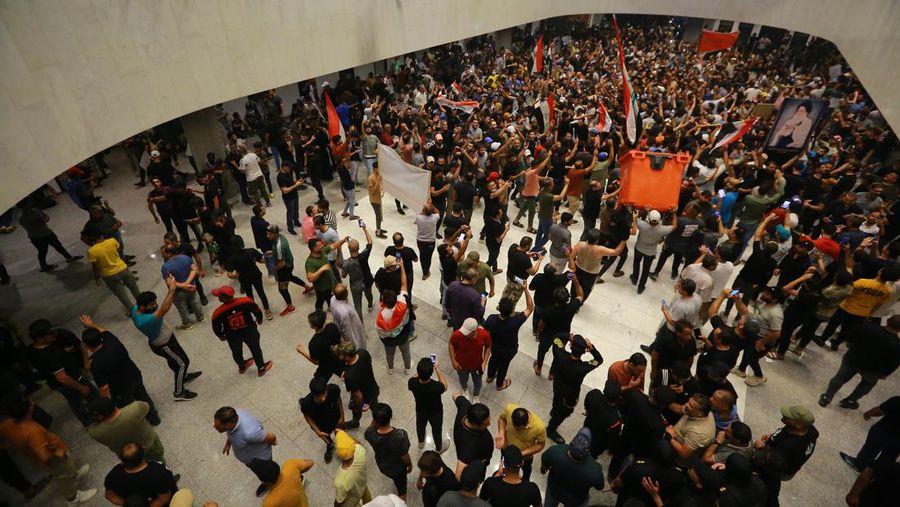 Pendukung ulama Irak Moqtada Sadr berkumpul di luar parlemen Irak di Zona Hijau keamanan tinggi ibukota Baghdad, saat mereka memprotes pencalonan blok saingan untuk perdana menteri, pada 27 Juli 2022. (AFP via Getty Images/AHMAD AL-RUBAYE)