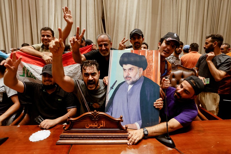 Pendukung ulama Irak Moqtada Sadr berkumpul di luar parlemen Irak di Zona Hijau keamanan tinggi ibukota Baghdad, saat mereka memprotes pencalonan blok saingan untuk perdana menteri, pada 27 Juli 2022. (AFP via Getty Images/AHMAD AL-RUBAYE)