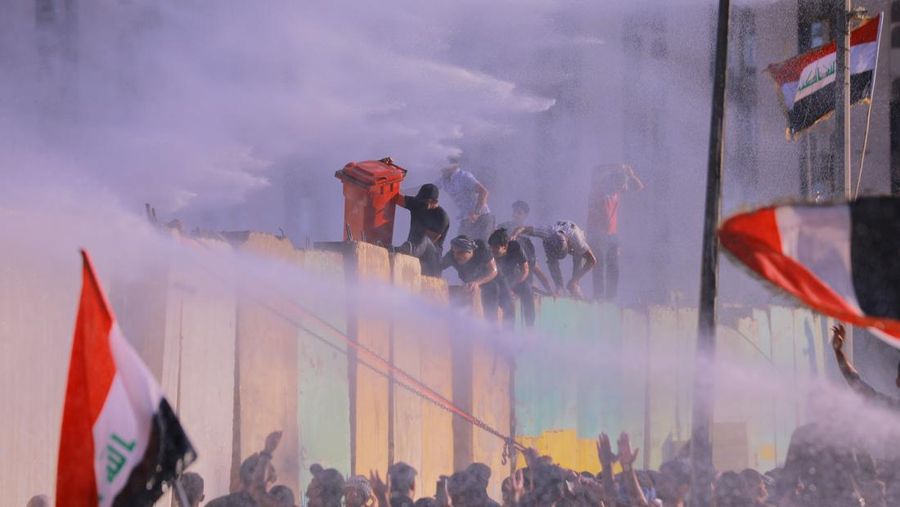 Polisi menembakkan rentetan gas air mata dalam upaya untuk menghentikan para pengunjuk rasa. di Baghdad. (dpa/picture alliance via Getty I/picture alliance)