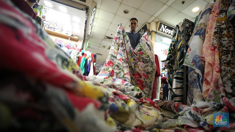 Pekerja mengukur kain impor yang berasal dari Cina di kawasan pusat teksil di Jakarta, Selasa (2/8/2022). (CNBC Indonesia/Tri Susilo)
