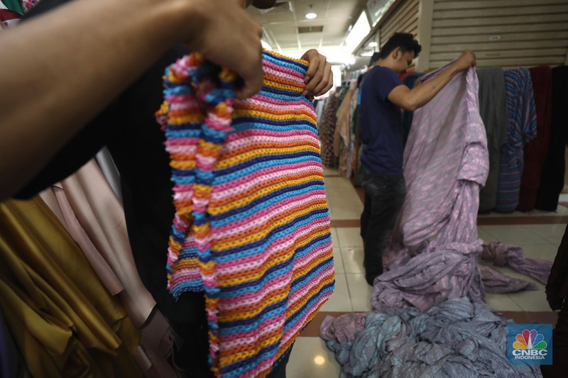 Pekerja mengukur kain impor yang berasal dari Cina di kawasan pusat teksil di Jakarta, Selasa (2/8/2022). (CNBC Indonesia/Tri Susilo)