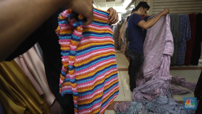 Pekerja mengukur kain impor yang berasal dari Cina di kawasan pusat teksil di Jakarta, Selasa (2/8/2022). (CNBC Indonesia/Tri Susilo)