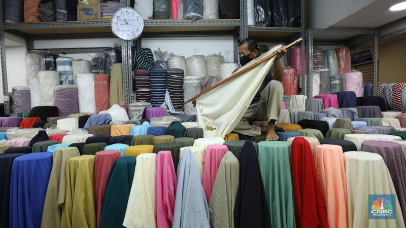 Pekerja mengukur kain impor yang berasal dari Cina di kawasan pusat teksil di Jakarta, Selasa (2/8/2022). (CNBC Indonesia/Tri Susilo)