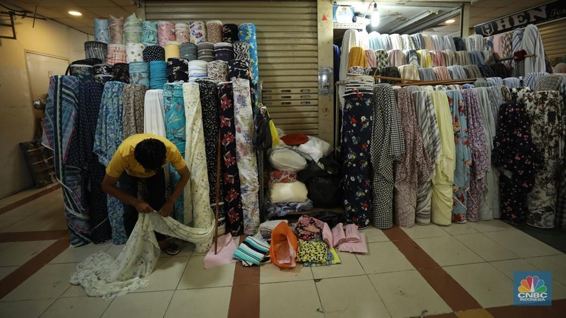 Pekerja mengukur kain impor yang berasal dari Cina di kawasan pusat teksil di Jakarta, Selasa (2/8/2022). (CNBC Indonesia/Tri Susilo)