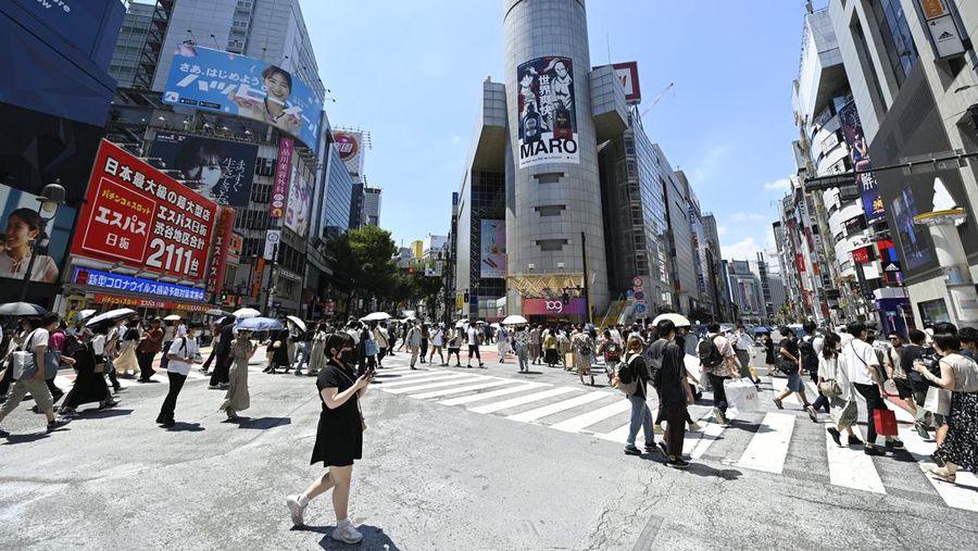 TOKYO, JAPAN - JULY 31: People walking in the street wear a protective mask as a precaution against the coronavirus (Covid-19) on July 31, 2022 in Tokyo, Japan. Japanese capital is swept by a heat wave whose temperature reaches 38 degrees Celsius and more in certain districts and suburbs close to the city. While Japan is facing a new wave of Covid-19 contamination in recent days, the capital is recording contamination records this week amounting to 40,000 people in just one day, a number never recorded in such a short time in Japan. Following the growing number of infected people in Tokyo, several major events related to the summer season have been canceled or restricted in order to contain the spread of the new omicron strain of Covid-19. (Photo by David Mareuil/Anadolu Agency via Getty Images)