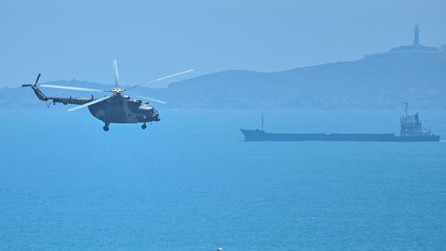 A Chinese military helicopter flies past Pingtan island, one of mainland China's closest point from Taiwan, in Fujian province on August 4, 2022, ahead of massive military drills off Taiwan following US House Speaker Nancy Pelosi's visit to the self-ruled island. - China is due on August 4 to kick off its largest-ever military exercises encircling Taiwan, in a show of force straddling vital international shipping lanes following a visit to the self-ruled island by US House Speaker Nancy Pelosi. (Photo by Hector RETAMAL / AFP) (Photo by HECTOR RETAMAL/AFP via Getty Images)