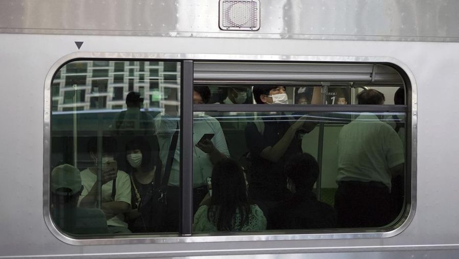 People wearing protective masks to help curb the spread of the coronavirus ride a train Wednesday, July 27, 2022, in Tokyo. (AP Photo/Eugene Hoshiko)